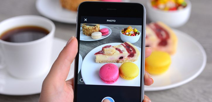 İstanbul, Turkey - January 26, 2016: Woman hands holding an Apple iPhone 6 and taking photos of a food with Instagram application. iPhone is a touchscreen smart phone produced by Apple Inc.